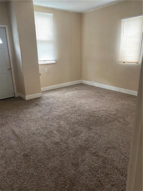 empty room with baseboards and carpet flooring