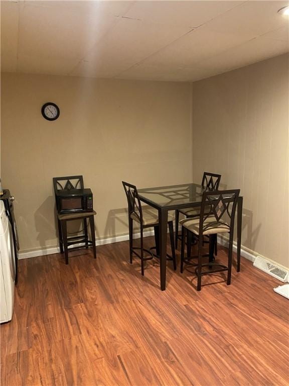 dining space with baseboards and wood finished floors