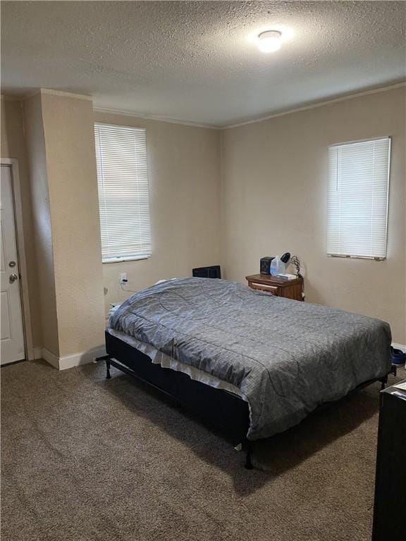 carpeted bedroom featuring ornamental molding and a textured ceiling