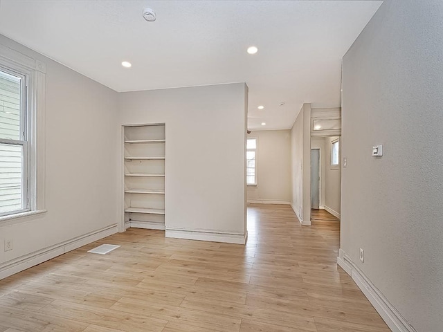 spare room with recessed lighting, baseboards, built in features, and light wood finished floors