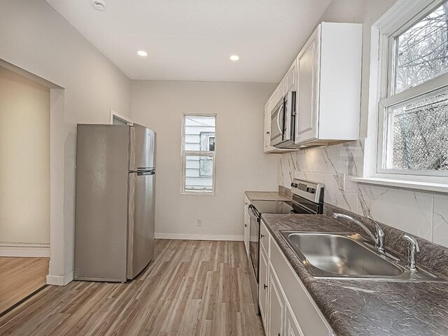 kitchen with plenty of natural light, a sink, dark countertops, and stainless steel appliances