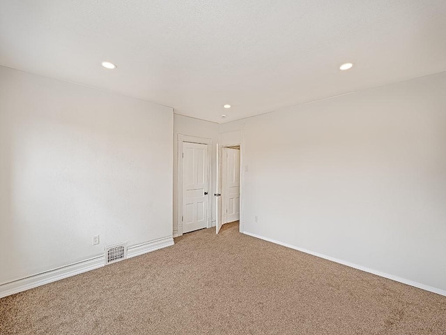 carpeted empty room featuring baseboards, recessed lighting, and visible vents