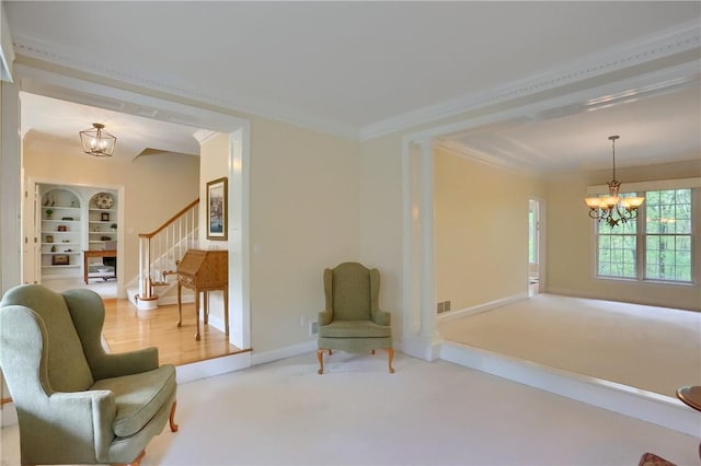 sitting room featuring baseboards, a chandelier, ornamental molding, and stairway