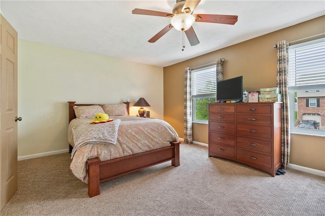 bedroom featuring baseboards, ceiling fan, and light colored carpet