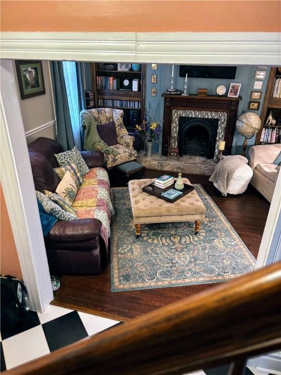 living area with a tiled fireplace and wood finished floors