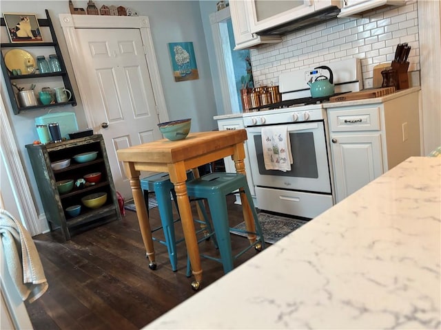 kitchen with white appliances, dark wood-style flooring, backsplash, and white cabinetry
