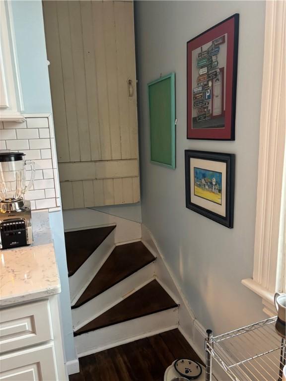 stairway with baseboards and wood finished floors