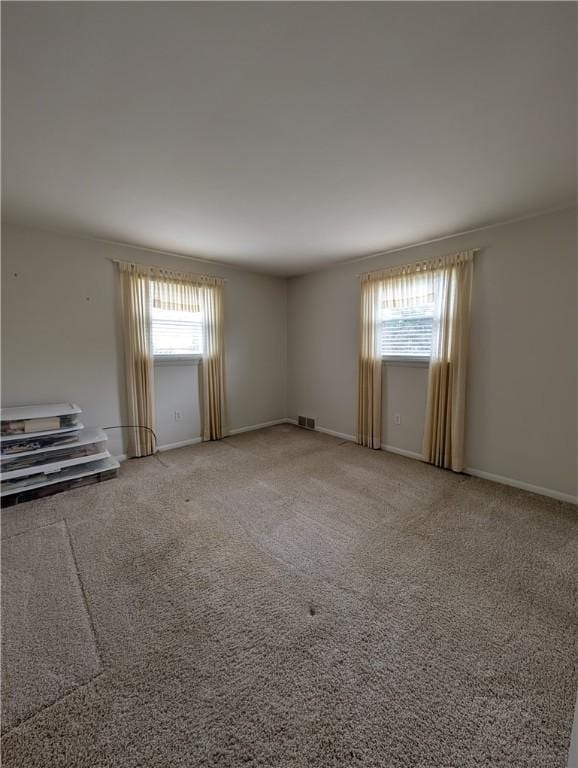carpeted empty room with baseboards and visible vents