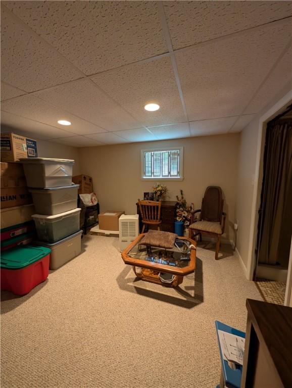 carpeted living area with a drop ceiling and recessed lighting
