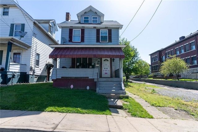 traditional style home with a chimney, a porch, and a front yard