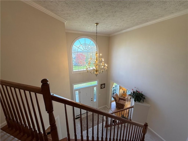 staircase featuring crown molding, baseboards, a textured ceiling, carpet, and a notable chandelier