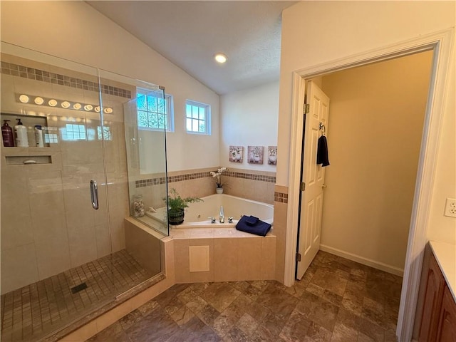 full bathroom with vanity, stone finish flooring, a shower stall, vaulted ceiling, and a bath