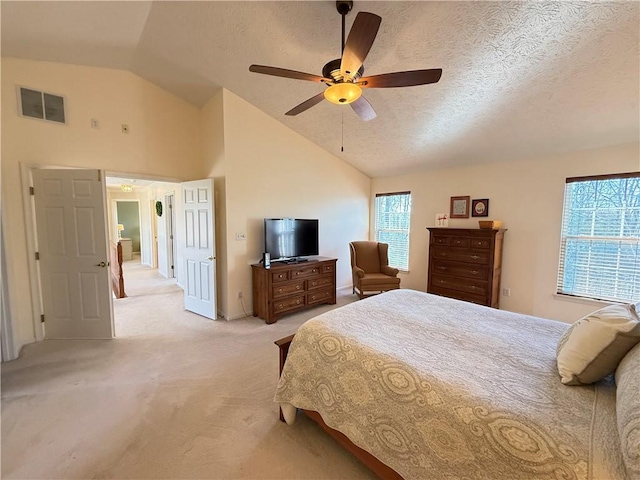 bedroom with visible vents, a textured ceiling, vaulted ceiling, and light carpet