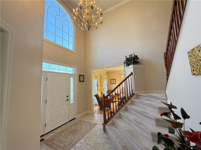 foyer entrance featuring baseboards, a notable chandelier, stairs, and a towering ceiling