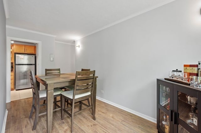 552 N Neville St Unit 26, Oakland, PA 15213 - dining room with light wood-type flooring, ornamental molding, baseboards, and a bar