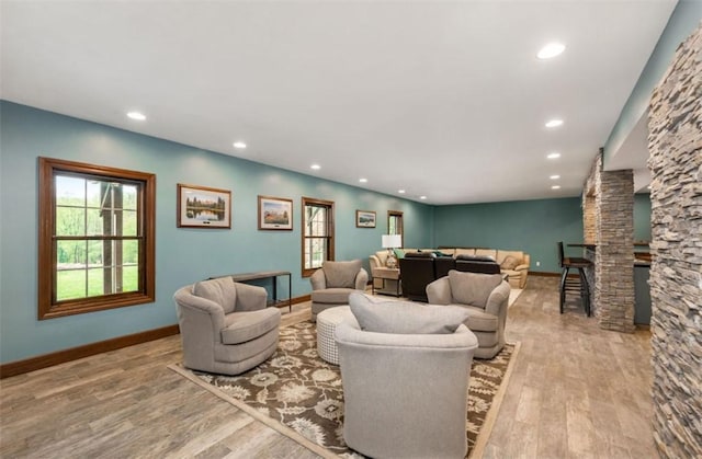 living area with recessed lighting, baseboards, wood finished floors, and a healthy amount of sunlight