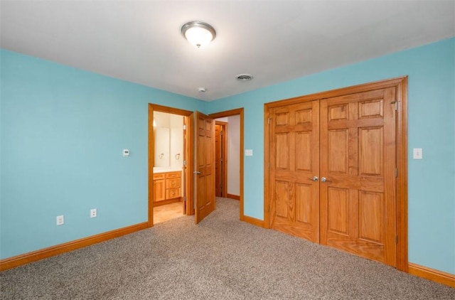 unfurnished bedroom featuring baseboards, visible vents, a closet, and light colored carpet