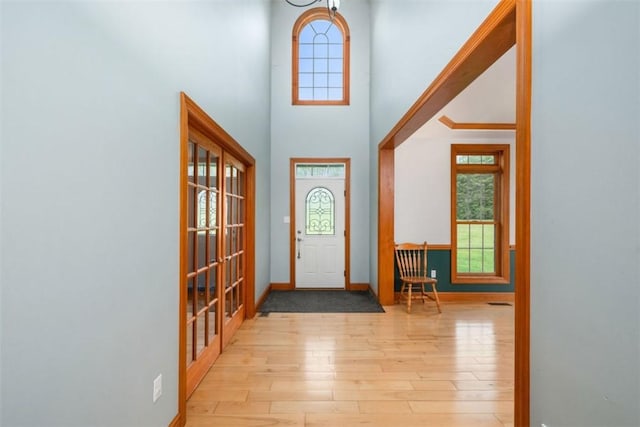 entrance foyer featuring baseboards, a high ceiling, and hardwood / wood-style floors
