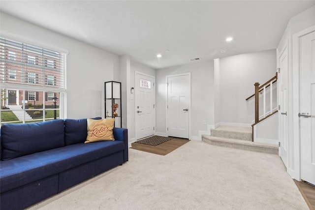 living room featuring stairs, visible vents, recessed lighting, carpet floors, and baseboards