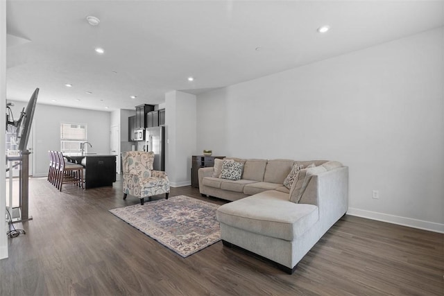 living area featuring dark wood-style flooring, baseboards, and recessed lighting