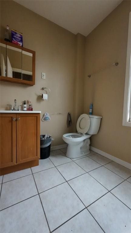 bathroom featuring toilet, baseboards, tile patterned flooring, and vanity