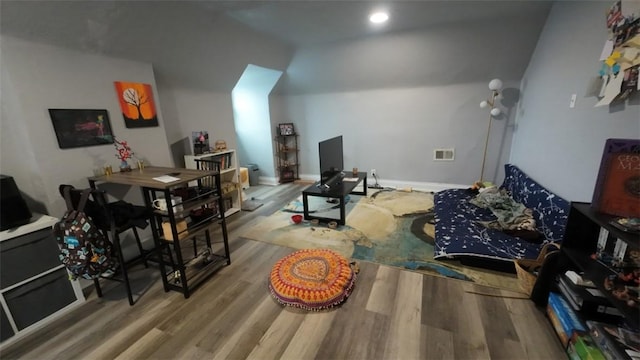 living room featuring baseboards, visible vents, wood finished floors, and lofted ceiling