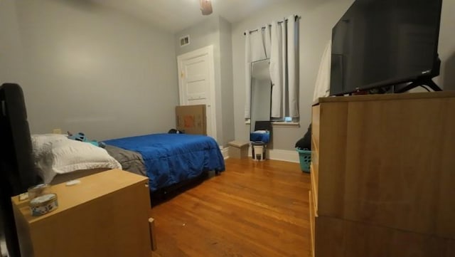 bedroom with vaulted ceiling, ceiling fan, visible vents, and wood finished floors