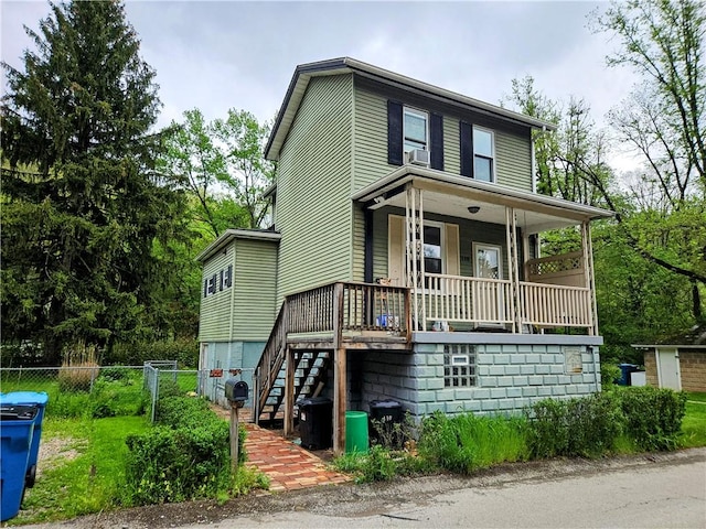 view of front of house featuring a porch, fence, and stairs