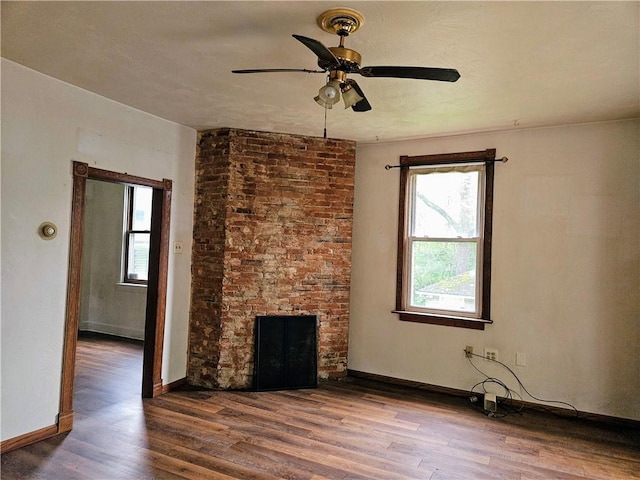 unfurnished living room featuring a ceiling fan, baseboards, a healthy amount of sunlight, and wood finished floors