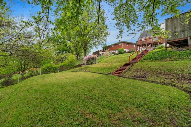 view of yard featuring fence, a wooden deck, and stairway