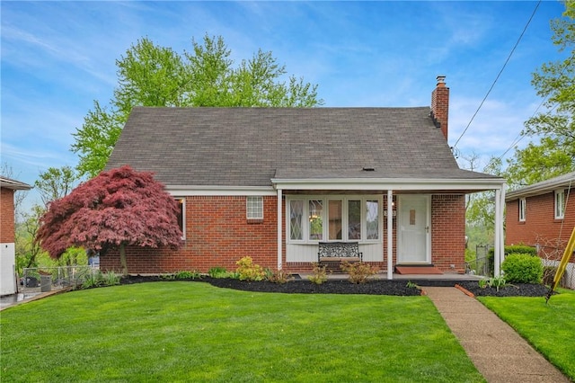 view of front of property featuring a chimney, a front lawn, and brick siding