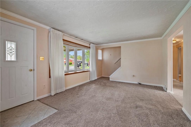 carpeted foyer featuring crown molding, a textured ceiling, baseboards, and tile patterned flooring