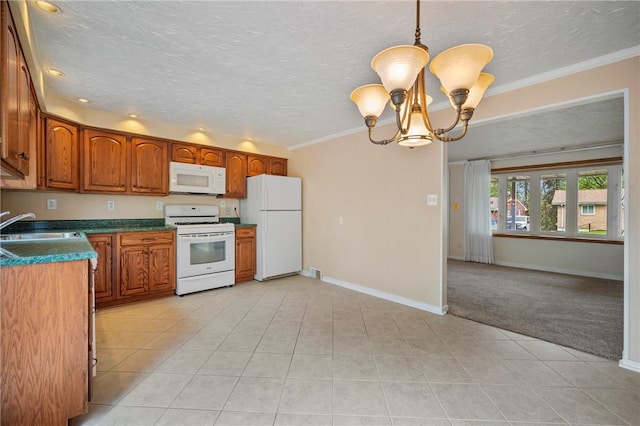 kitchen with brown cabinetry, dark countertops, white appliances, baseboards, and a sink