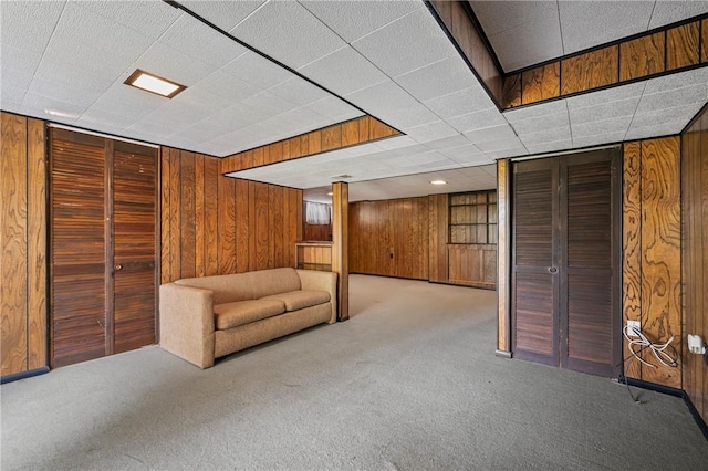 finished basement featuring wooden walls and carpet