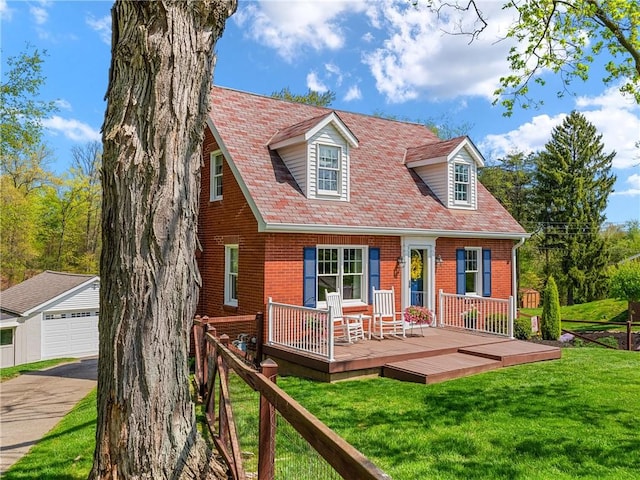 view of front facade featuring brick siding, a garage, an outbuilding, a wooden deck, and a front lawn