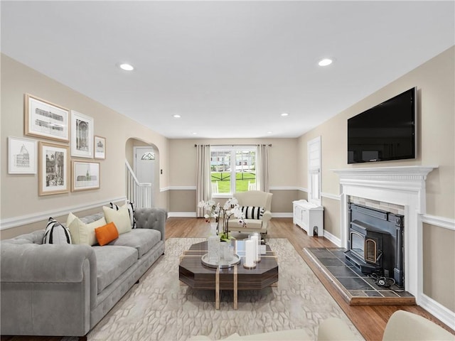 living area with recessed lighting, arched walkways, baseboards, and wood finished floors