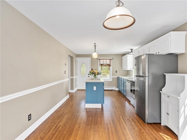kitchen featuring wood finished floors, white cabinets, a baseboard heating unit, light countertops, and a kitchen island