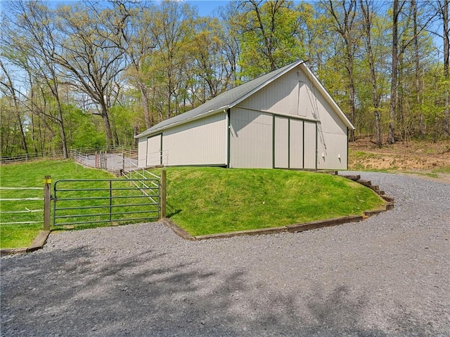 view of pole building featuring a gate, fence, and a lawn