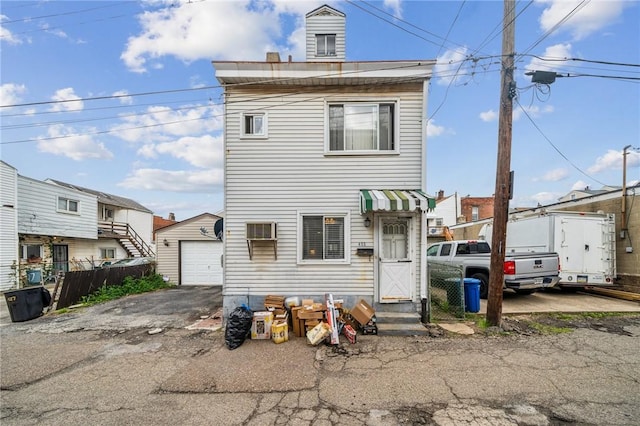 view of front facade with an outbuilding, a residential view, a garage, and entry steps