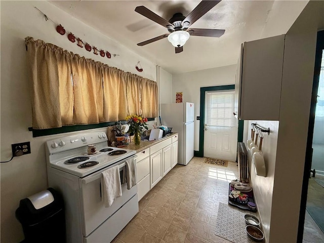 kitchen with white appliances, light countertops, a ceiling fan, and white cabinets