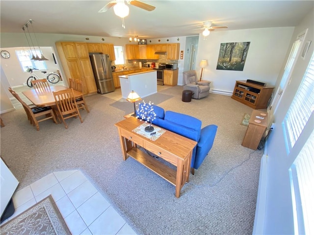 living room featuring light colored carpet, baseboards, a ceiling fan, and light tile patterned floors