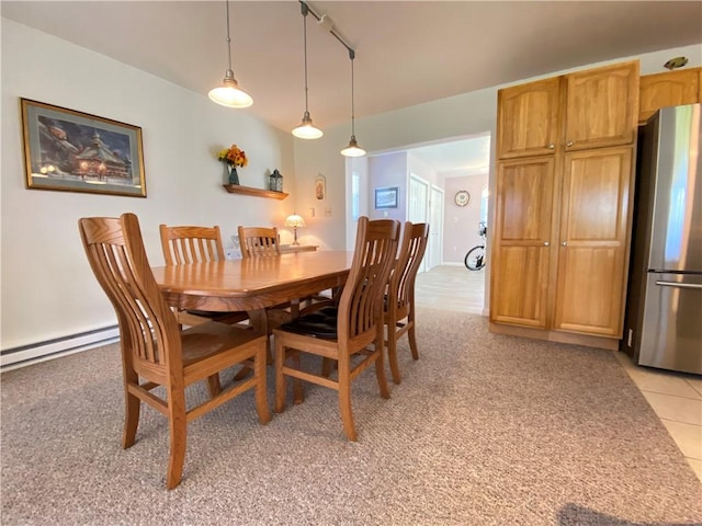 dining room featuring light colored carpet, track lighting, and a baseboard radiator