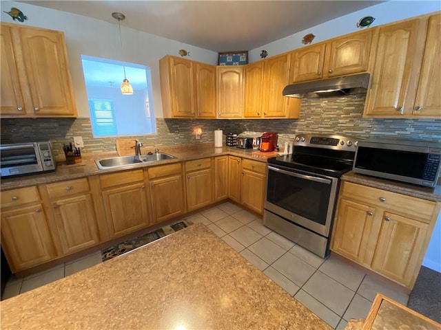 kitchen featuring under cabinet range hood, decorative backsplash, stainless steel appliances, and a sink