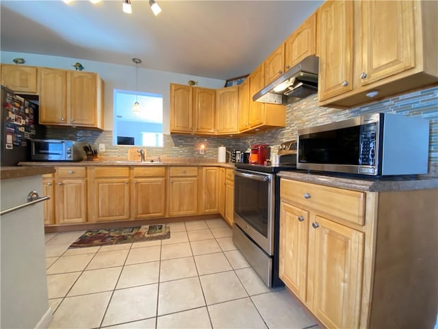 kitchen with light tile patterned floors, stainless steel appliances, light brown cabinets, under cabinet range hood, and tasteful backsplash