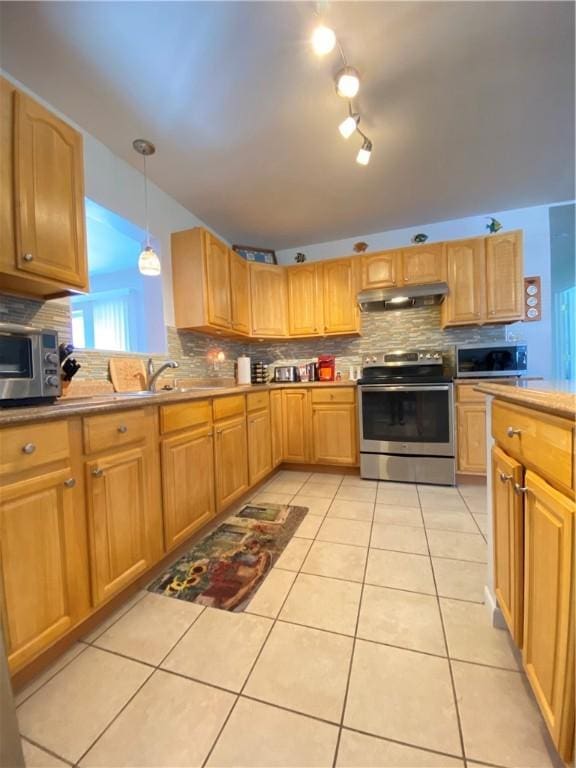 kitchen featuring under cabinet range hood, appliances with stainless steel finishes, and tasteful backsplash