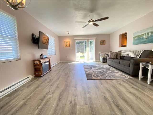 living area featuring light wood finished floors, a baseboard radiator, baseboards, and a ceiling fan