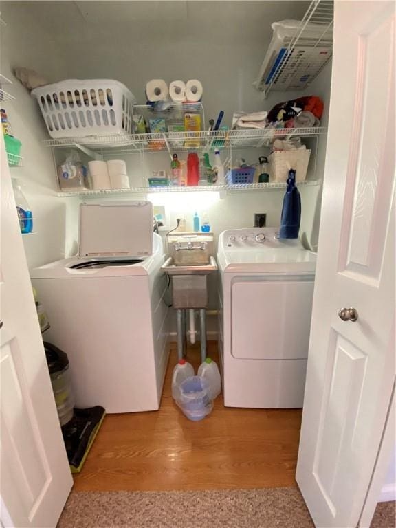 laundry area featuring washer and clothes dryer, laundry area, and wood finished floors