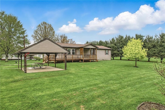 back of house featuring a yard, a gazebo, a wooden deck, and a patio