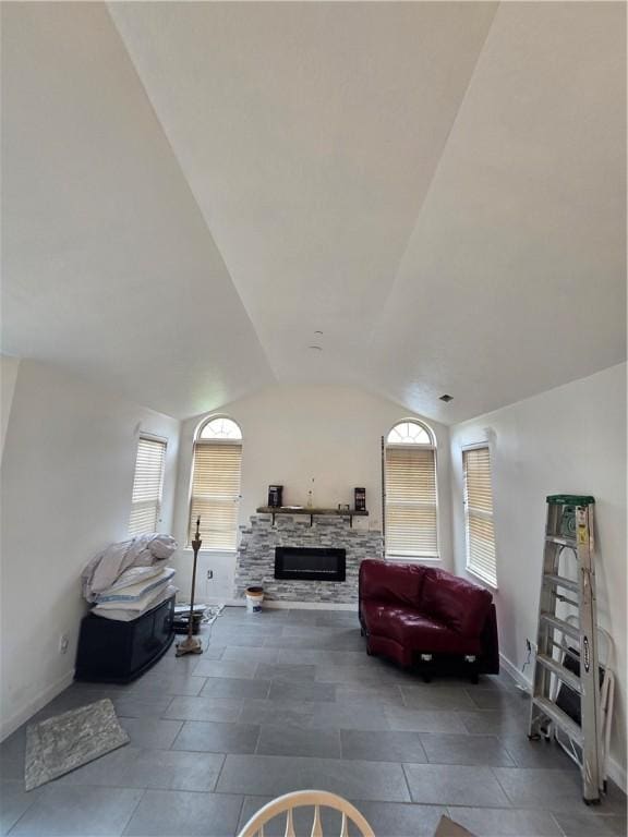 interior space featuring vaulted ceiling, a fireplace, and baseboards