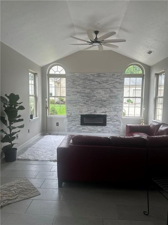 1608 Saint Andrews Dr, South Strabane, PA 15301 - living room with lofted ceiling, a stone fireplace, ceiling fan, and plenty of natural light